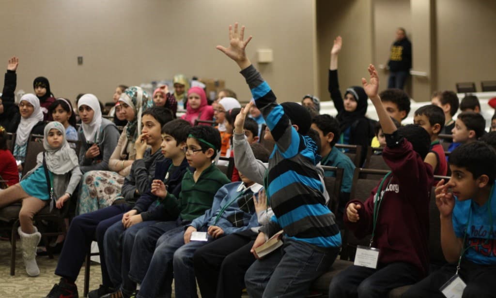 Youth raising hands during an interactive program